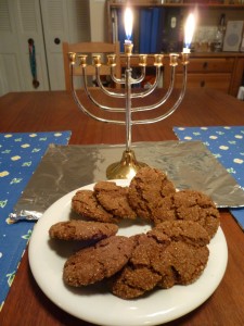 Vegan Molasses cookies in front of the Chanukah candles
