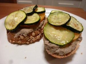 Fresh baked bread topped with homemade baba ganoush, yellow tomatoes, and baked zucchini slices